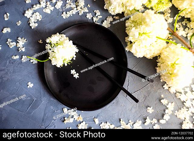 Summer table setting with white Viburnum opulus 'Roseum' flowers on rustic background