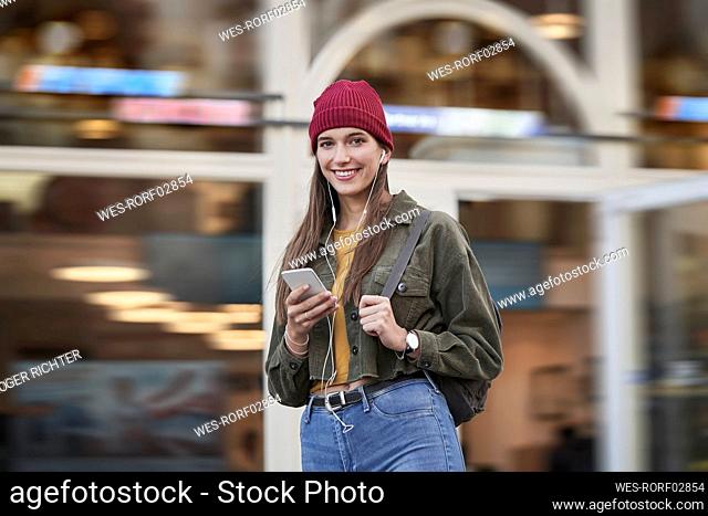 Smiling woman standing in front of building