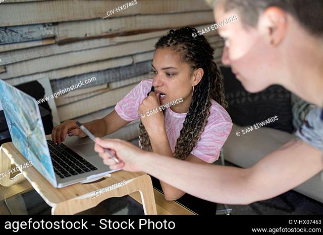 Young female entrepreneurs working at laptop