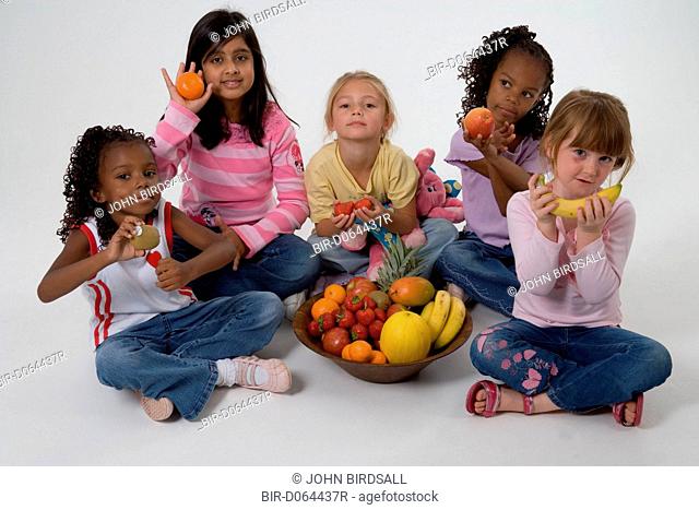 Group of children holding fruit