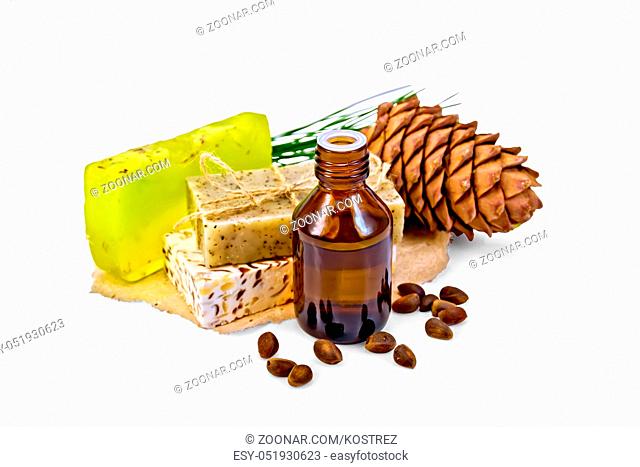 Cedar oil in a bottle, a bump, three homemade soap nuts isolated on white background