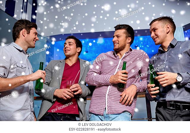 nightlife, party, friendship, leisure and people concept - group of smiling male friends with beer bottles drinking in nightclub and snow effect