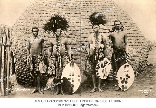 Four Zulu Warriors in traditional costume carrying clubs and shields