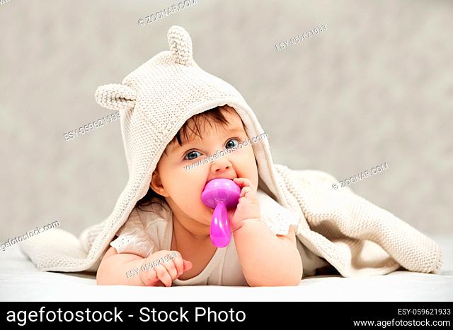 Portrait of baby girl playing with toy on blanket at home