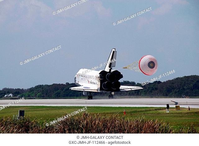 Space Shuttle Discovery's drag chute is deployed as the spacecraft rolls toward wheels stop on runway 15 of the Shuttle Landing Facility at NASA's Kennedy Space...