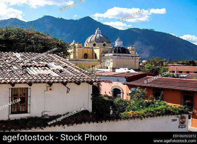 Overview of Antigua de Guatemala with colonial houses and Iglesia La Merced with mountains