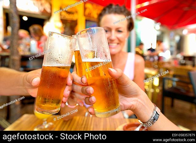 Portrait of Happy Friends Drinking and Toasting Beer Outdoors at Restaurant
