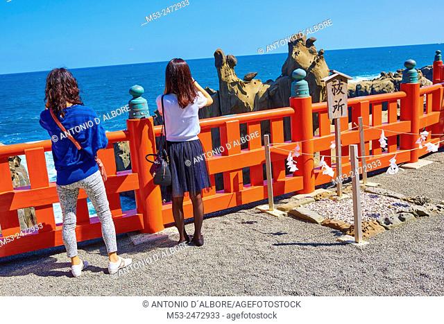 Two japanese girls taking a photo to the Sea of Hyuga at the terrace of Udo-Jingu Shrine. Nichinan City. Miyazaki Prefecture. Japan