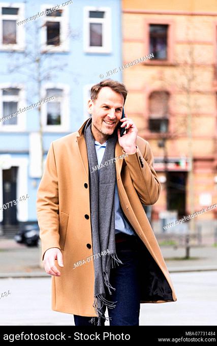 Businessman on the way to work with Smartphone, half portrait