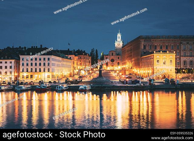 Stockholm, Sweden. Scenic Famous View Of Embankment In Old Town Of Stockholm In Night Lights. Great Church Or Church Of St. Nicholas And Royal Palace