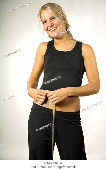 young woman messures her waist