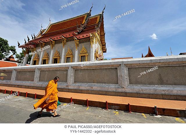 monk walking past Wat Intharawihan, also known as Wat Indravihan , built during the later Ayutthaya period, is one of the most frequented temples in Bangkok