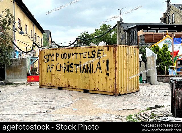 08 August 2023, Denmark, Kopenhagen: A container with the inscription ""Stop udnyttelse af Christiania!"" (Stop the exploitation of Christiania) stands in the...