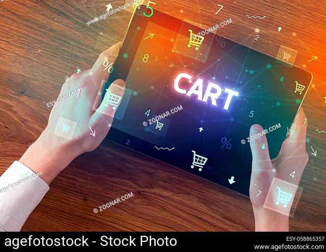 Close-up of a hand holding tablet with CART inscription, online shopping concept