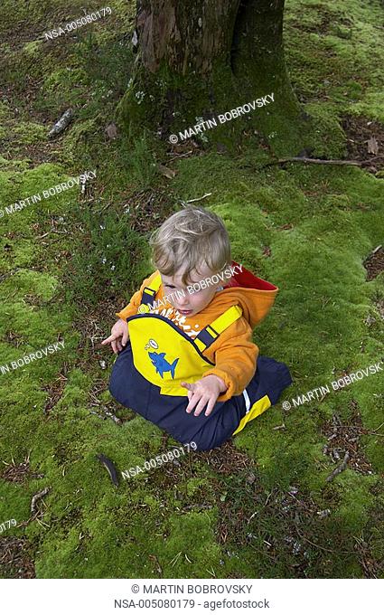 baby on mossy forest soil