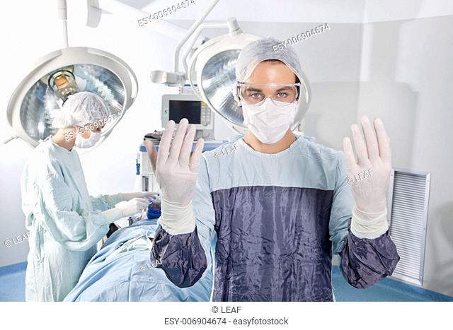 Male surgeon asking for gloves