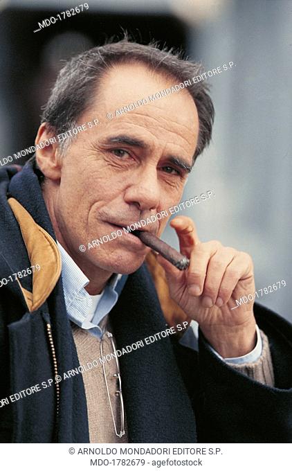 Roberto Vecchioni smoking the cigar. Italian singer-songwriter and writer Roberto Vecchioni posing with a cigar in his mouth. Italy, 1999