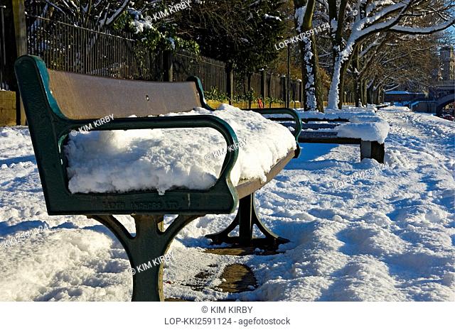 England, North Yorkshire, York. A thick covering of snow on a bench by the River Ouse in York