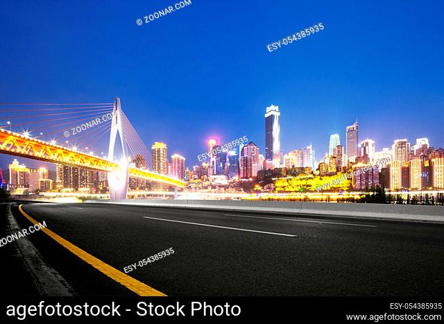 empty asphalt road and suspension bridge and cityscape of chongqing at night