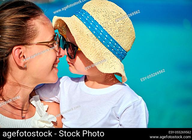 Three year old toddler boy on beach eskimo kissing his mother. Summer family vacation at Maldives