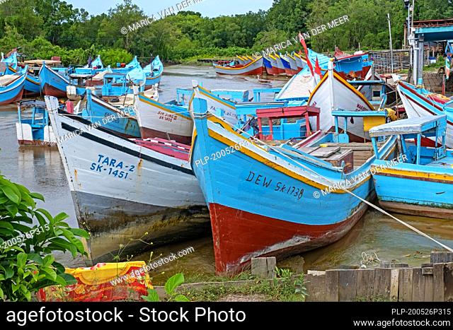 Colourful traditional wooden fishing boats moored along the coast of Guyana, South-America