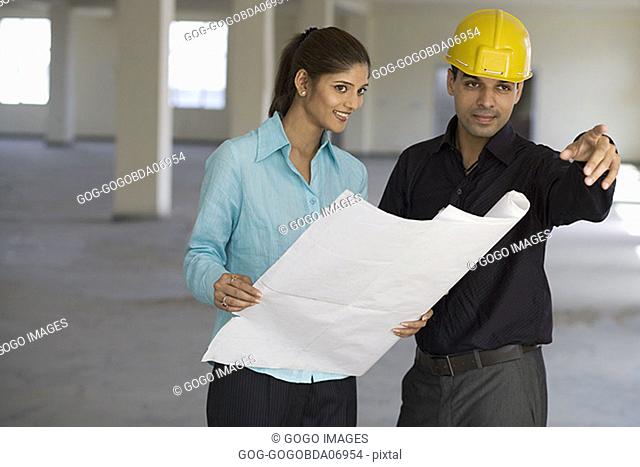 Businesspeople looking at blueprints