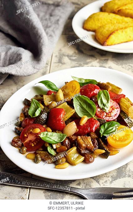 Caponata with peppers and cherry tomatoes served with polenta slices