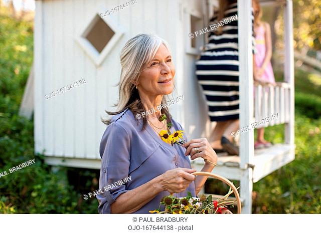 Older woman picking flowers outdoors