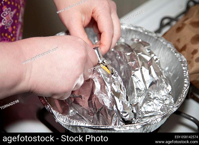 Woman unwrapping aluminum foil from a pair of fresh tacos