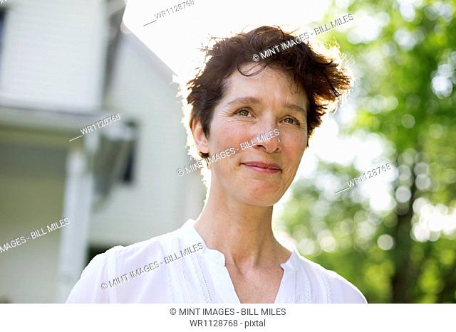An organic farm in the countryside near Woodstock. Summer party. A mature woman smiling