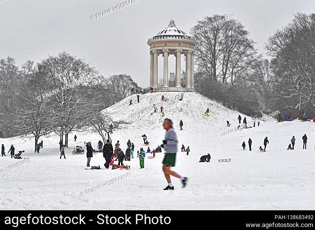 Weather picture / Winter in the English Garden in Muenchen - numerous sledge drivers and tobogganists - but also a jogger in shorts frolic in the snow on the...