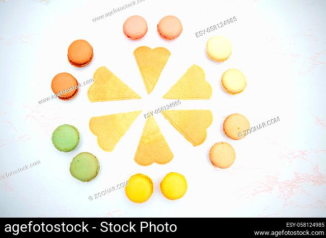 Fun flat lay composition of the colorful and sweet tasting small French cake macaron or macaroon combined with cookies