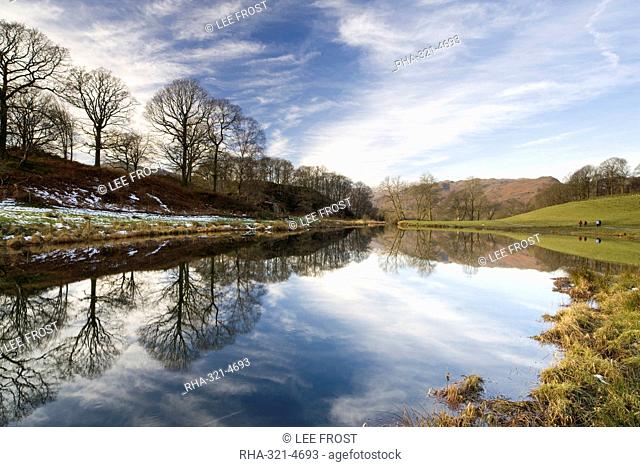 River Brathay on a calm winter's day with reflections of trees and distant fells, near Ambleside, Lake District National Park, Cumbria, England, United Kingdom