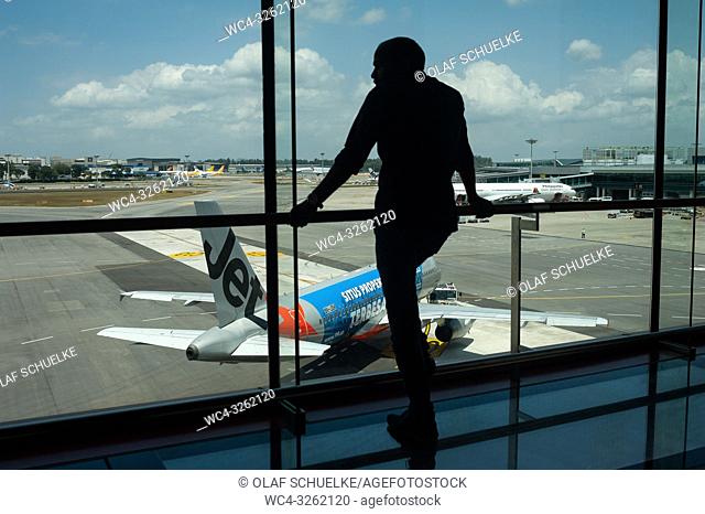 Singapore, Republic of Singapore, Asia - A visitor is looking at a Jetstar Airbus A320 from the Terminal 1 viewing mall at Singapore's Changi Airport