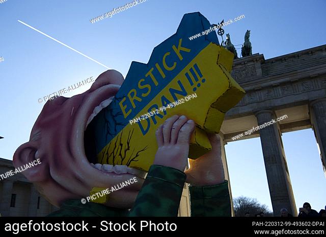 12 March 2022, Berlin: The Putin float of Düsseldorf carnival float maker Jacques Tilly drives past the Brandenburg Gate
