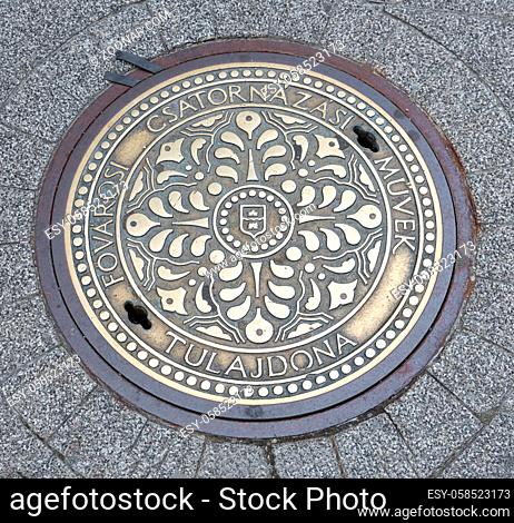 Ornate manhole cover downtown in Budapest, capital city of Hungary