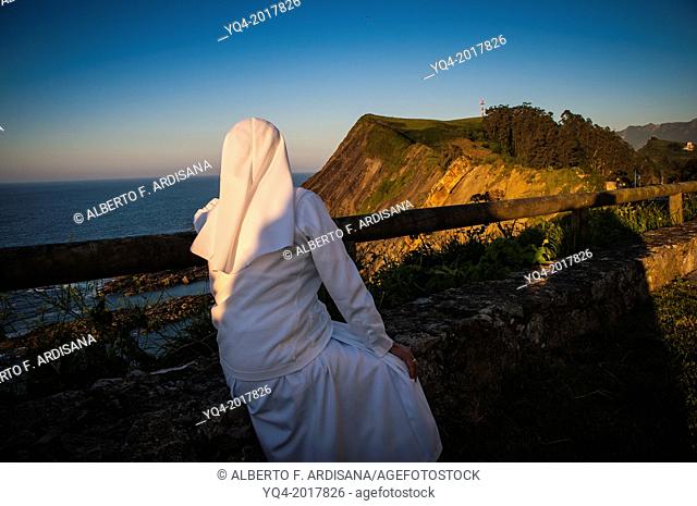 A nun contemplates the Cantabrian sea horizon. Asturias.España