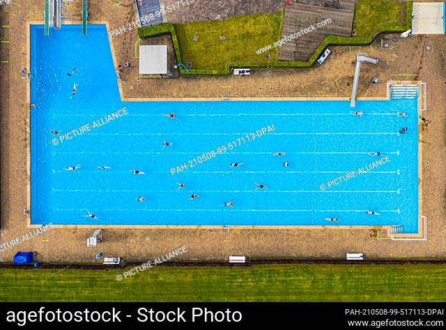 08 May 2021, North Rhine-Westphalia, Billerbeck: Guests swim their laps in the open-air swimming pool (shot with drone). After six months
