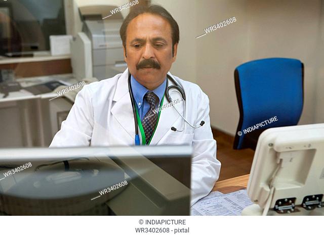 Doctor looking at CT scan on computer screen