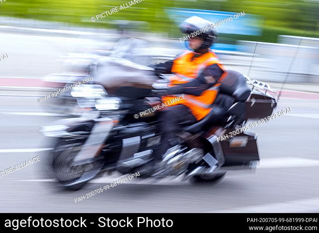 04 July 2020, Mecklenburg-Western Pomerania, Schwerin: One of more than 1, 000 motorcyclists rides his vintage motorcycle through the city centre in a vehicle...