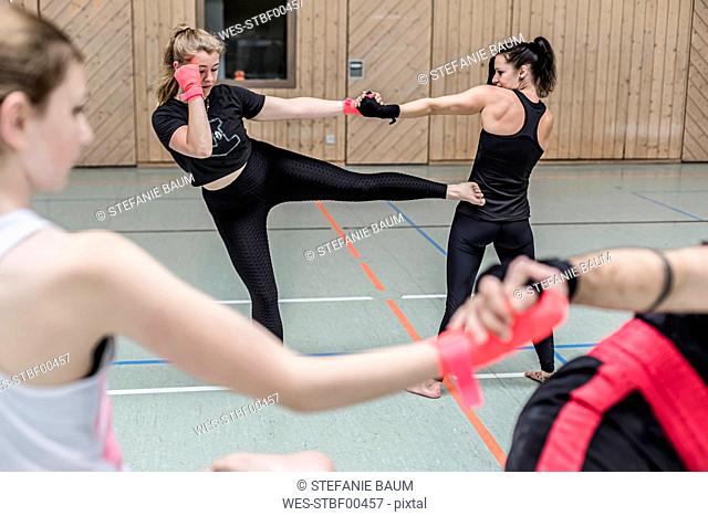 Female kickboxers practising in sports hall