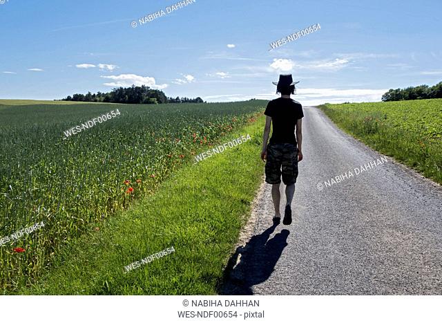Germany, Bavaria, Leinach, man walking in rural landscape