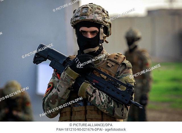 10 December 2018, Iraq, Baghdad: An Iraqi military soldier holds up his weapon as he takes part in a ceremonial military drill marking the first anniversary of...