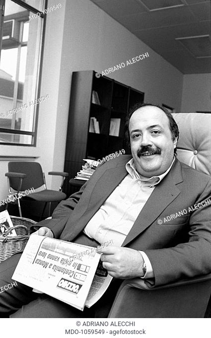 Maurizio Costanzo and the newspaper L'Occhio. The Italian journalist and TV author Maurizio Costanzo sitting reading the tabloid newspaper founded by him