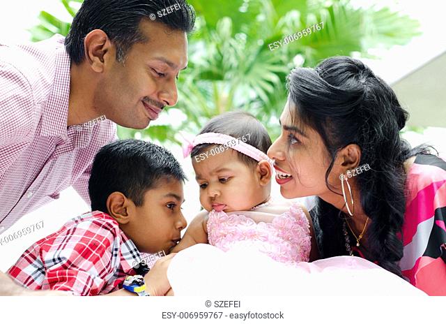 Happy Indian family with two children having fun at home garden