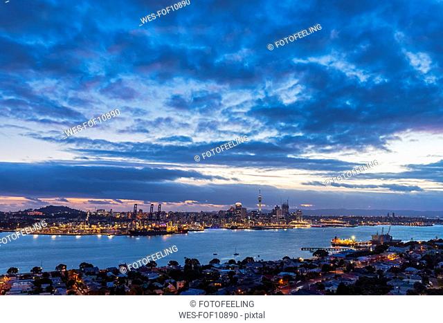 Modern buildings by sea against cloudy sky at dusk in Auckland, New Zealand