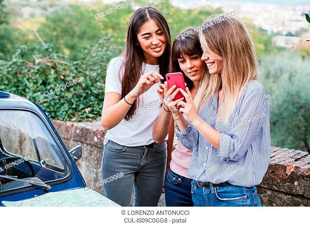 Friends using smartphone in countryside