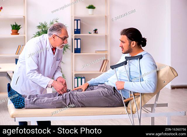 Leg injured man visiting old doctor osteopath