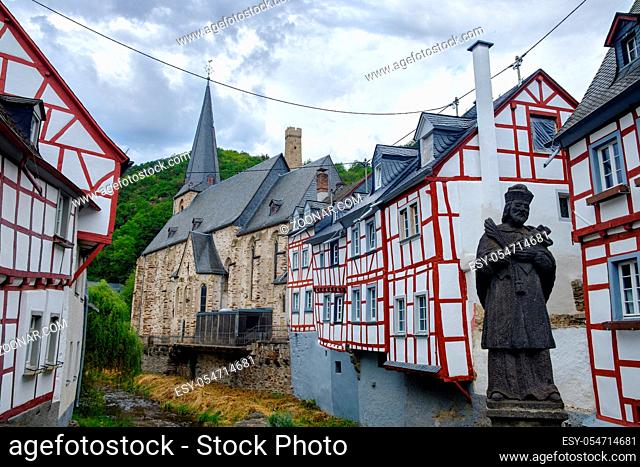The beautiful and picturesque village of Monreal with John of Pomuk Statue at the stone bridge in Eifel region, Germany