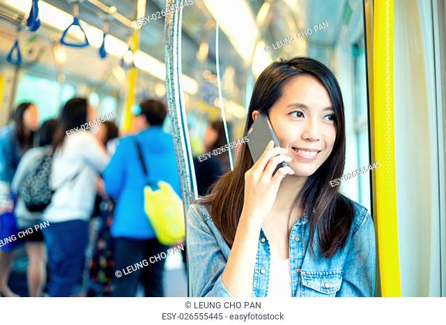 Woman talk to phone inside train compartment